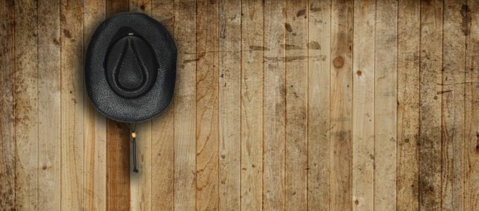 Cowboy hat, against an old barn background.