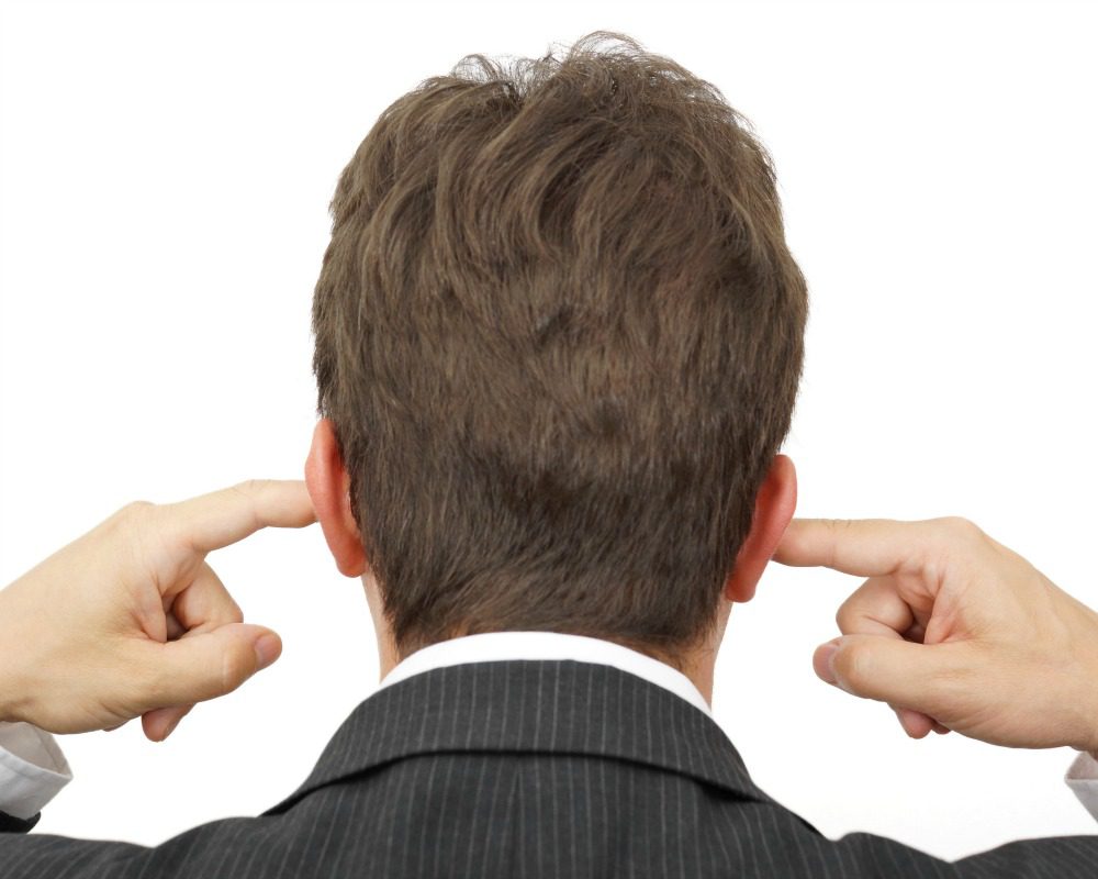 businessman blocking his ears with fingers