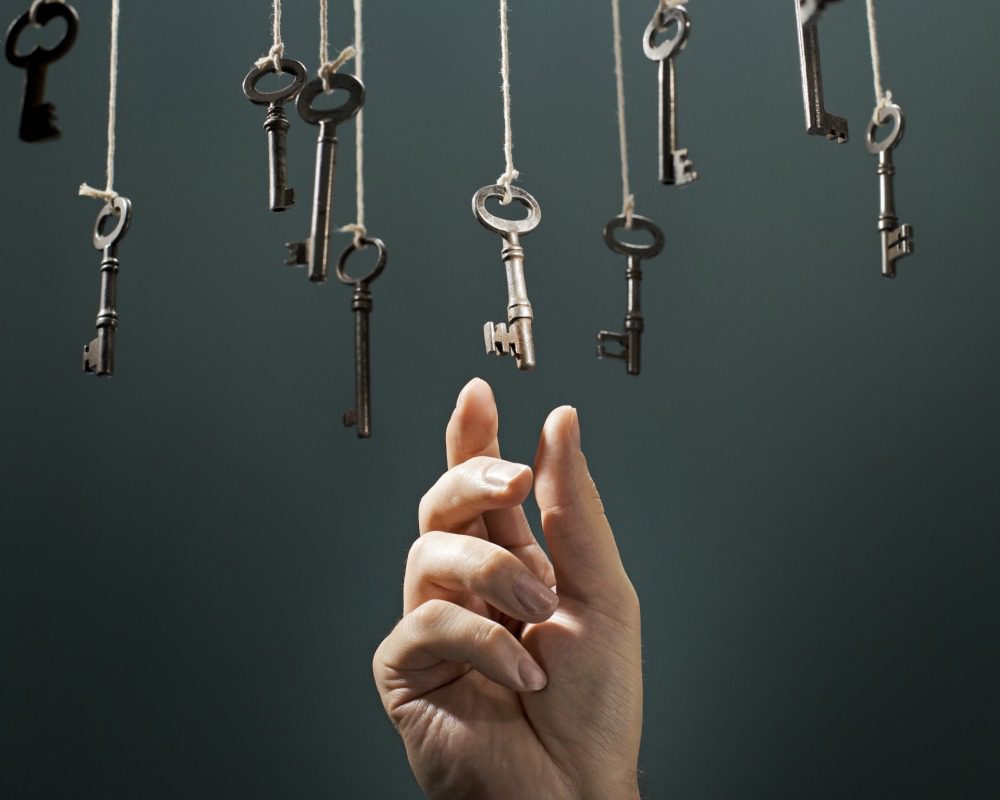 Hand choosing a hanging key amongst other ones.