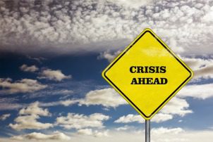 A crisis ahead road sign and blue sky