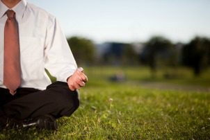 Businessman meditating in a park