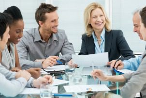 Group Of Happy Coworkers Discussing In Conference Room