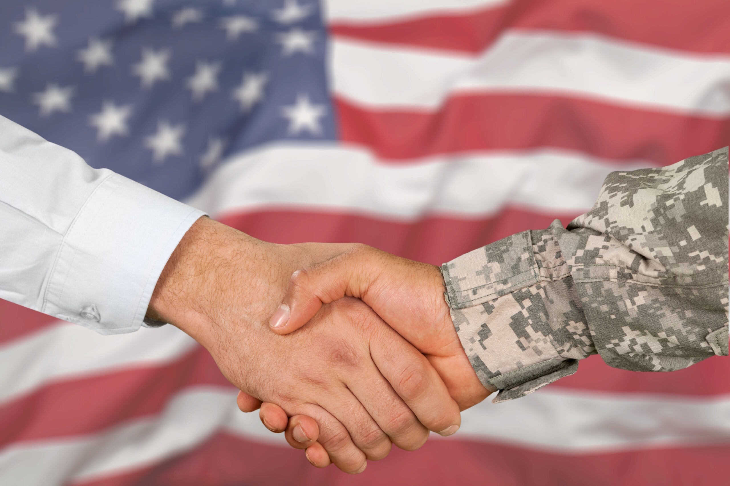 A veteran and a businessman shake hands.