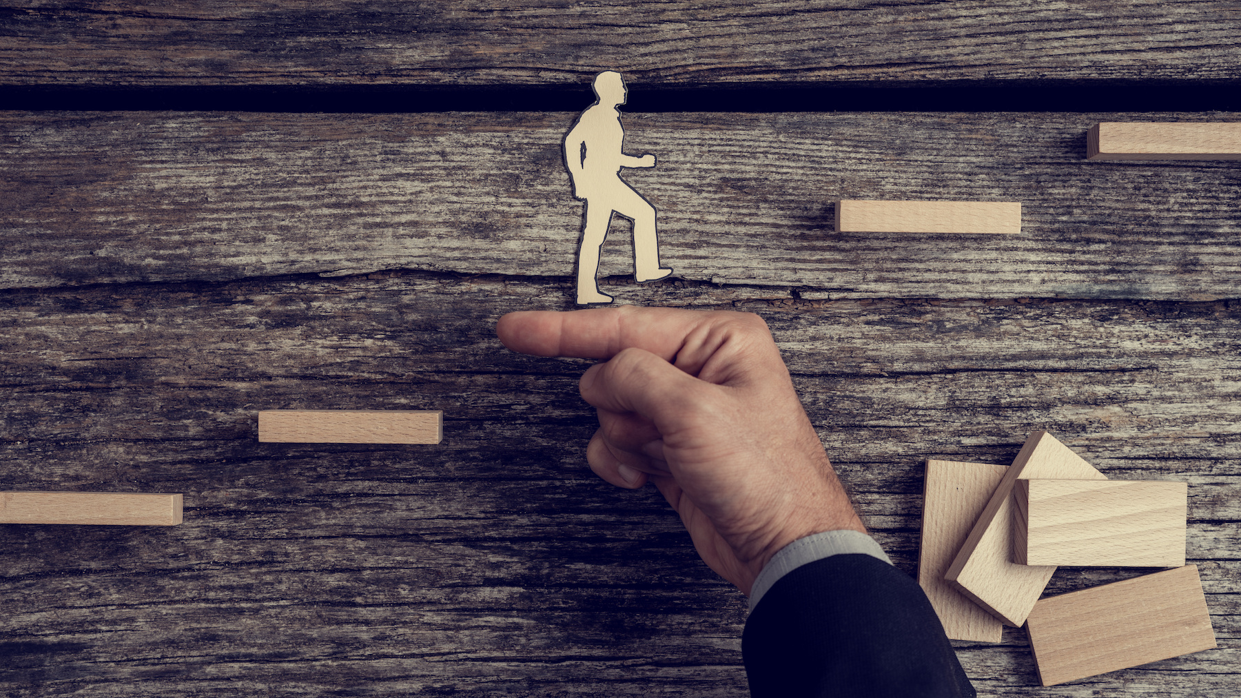 Businessman supporting a man climbing stairs